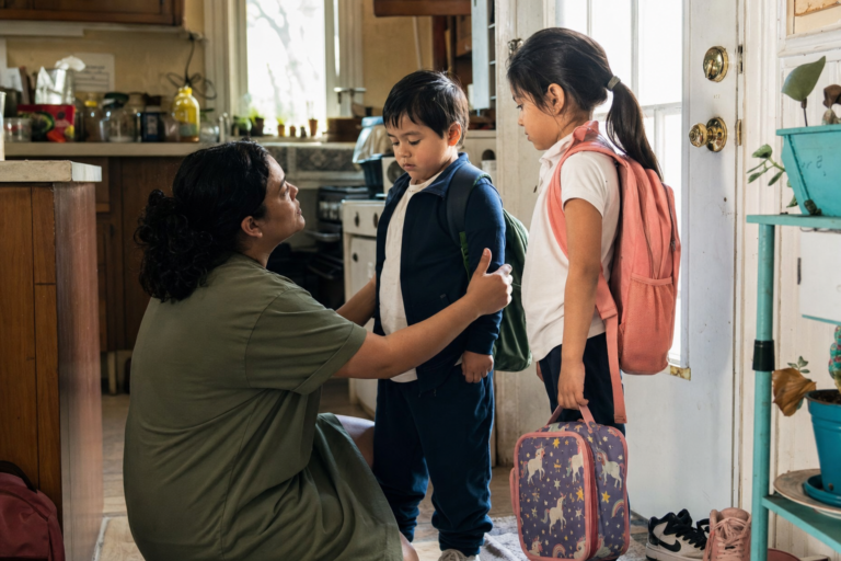 Latina mother comforting two young children after school in a family kitchen